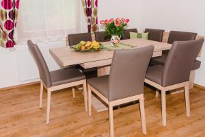 uma mesa de jantar com cadeiras e uma taça de fruta em Haus Lassacher em Sankt Michael im Lungau