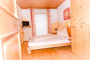 a small bedroom with a bed and a window at Haus Lassacher in Sankt Michael im Lungau