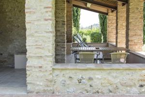 un patio al aire libre con mesa y sillas en Monteriggioni Suite en Monteriggioni
