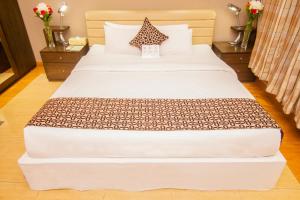 Llit o llits en una habitació de Rafflesia Serviced Apartments