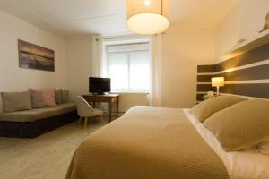 een slaapkamer met een bed, een bank en een bureau bij Casa Cosy Le Pouliguen in Le Pouliguen