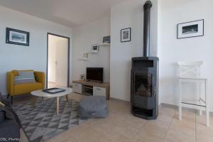 a living room with a fireplace and a tv at L'Eternel Estivant in Sète