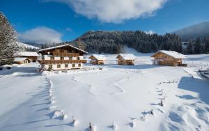 a winter scene of a lodge in the snow at Lehenriedl Chalet in Wagrain