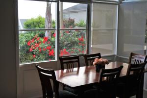 comedor con mesa, sillas y ventana en Oxford Rise Apartment, en Bayswater