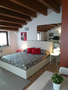 Un dormitorio con una cama grande con almohadas rojas. en Rovelli Room, en Bérgamo