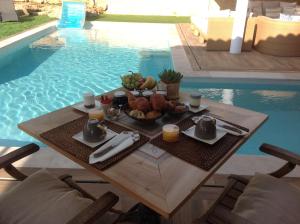 una mesa con comida junto a una piscina en la villa miel, en Opio