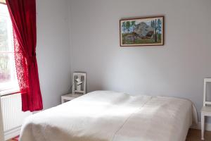 Un dormitorio con una cama blanca y una foto en la pared en 58 Turistvägen Järvsö en Järvsö