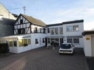 a white car parked in front of a house at Historisches Fachwerkhaus in Reifferscheid