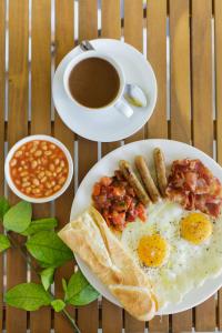 a table with two plates of food and a cup of coffee at Sorrento Beach Club & Kite Village in Phan Rang–Tháp Chàm