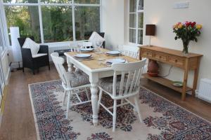 a dining room with a white table and chairs at Silhouette Cottage in Coleford