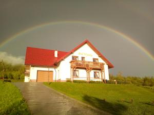 a rainbow in the sky over a house at Pokoje Gościnne Pod Wysotą in Wysowa-Zdrój