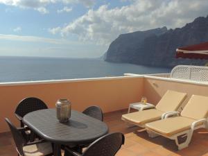 a balcony with a table and chairs and the ocean at Romantic Retreat with Marine View in Acantilado de los Gigantes