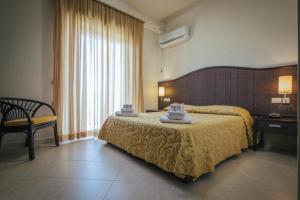 a hotel room with a bed and a chair at Hotel Costa Azul in Balestrate