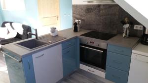 una cocina con armarios azules y fregadero en Le petit Kichon en Gérardmer