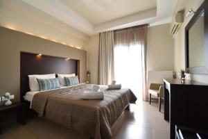 a hotel room with a large bed and a window at Hotel Dionisos in Leptokarya