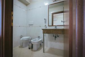 a bathroom with a toilet and a sink and a mirror at Hotel Costa Azul in Balestrate