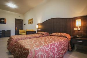 a hotel room with a large bed and a couch at Hotel Costa Azul in Balestrate