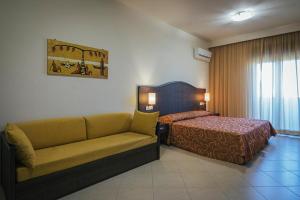 a hotel room with a couch and a bed at Hotel Costa Azul in Balestrate