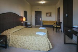 a bedroom with a bed and a living room at Hotel Costa Azul in Balestrate