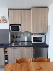 eine Küche mit Holzschränken und einem Holztisch in der Unterkunft BEL AURE 3 in Saint-Lary-Soulan