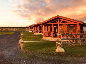 Northwick Farm Lodges في برودواي: صف اكواخ في ساحه بها سياج