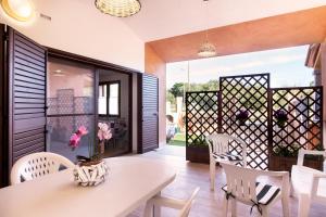 a dining room with a white table and chairs at Villetta Laura 350 mt Baia di Porto Frailis in Àrbatax +25 photos