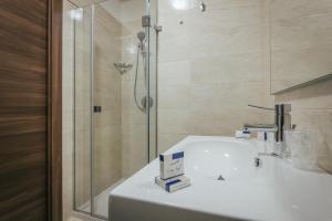 a bathroom with a shower and a white sink at Hotel Costa Azul in Balestrate