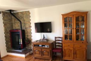 sala de estar con TV y chimenea en Appartement A La Montagne, en Palau-de-Cerdagne