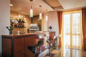 a kitchen with a bar with two stools at Hotel Costa Azul in Balestrate