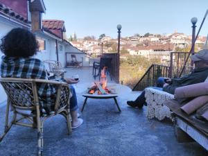 un groupe de personnes assises autour d'un foyer extérieur dans l'établissement Three Gracia, à Sighnaghi