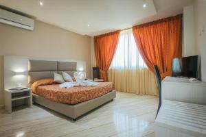 a bedroom with a bed and a television in it at Hotel Costa Azul in Balestrate
