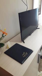 una scrivania con monitor e un libro sopra di Hotel Costa Azul a Balestrate