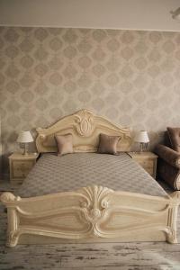 um quarto com uma grande cama de madeira e 2 mesas de cabeceira em Апартамент Барок em Lovech