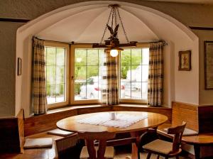 ein Esszimmer mit einem Tisch und einigen Fenstern in der Unterkunft Gasthof Obermair in Kiens