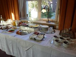 una mesa con un mantel blanco con comida. en Hotel Waldfriede, en Darmstadt