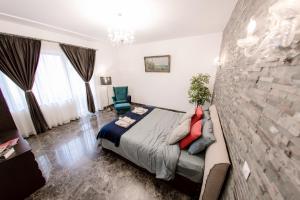 - une chambre avec un lit et un mur en pierre dans l'établissement Sun Residences Intercontinental, à Bucarest