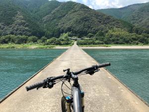 a bike parked on a bridge over a river at Shimanto Riverside Hideaway in Shimanto
