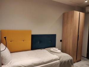 1 dormitorio con 1 cama y armario de madera en H33 Apartamenty en Bytom