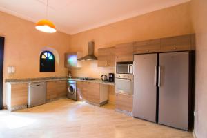 a large kitchen with stainless steel appliances and wooden cabinets at Villas Fleurs Marrakech in Marrakesh