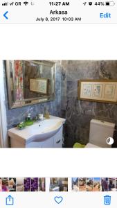 uma casa de banho com um lavatório, um WC e um espelho. em Pangiotas Pencione em Cárpatos