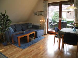 ein Wohnzimmer mit einem Sofa und einem Tisch in der Unterkunft Apartmenthaus Hansen in Büsum