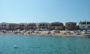 a group of people on a beach with umbrellas at On The Beach La Rena Beddha in Aglientu