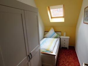 une petite chambre avec un lit et une fenêtre dans l'établissement Ferienwohnung Stollenwerk am Steinhuder Meer - Wunstorf OT Steinhude An der Schanze 7, à Steinhude