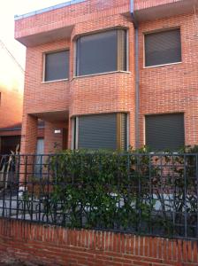 a brick building with a fence in front of it at Chalet Cantalejo in Cantalejo