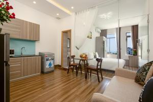 a hotel room with a bed and a table and chairs at Van apartment in Da Nang