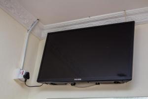 a flat screen tv hanging on a wall at Rugems Executive Lodge in Lusaka