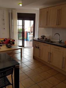 a kitchen with wooden cabinets and a table and a kitchen with a view at El Cotillo in El Cotillo