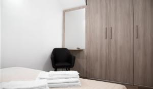 a bedroom with a black chair and a mirror at Cortile Osterio XIV in Cefalù