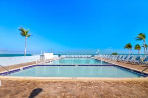 een zwembad naast een strand met palmbomen bij Fiesta Key RV Resort Premium Room 3 in Layton