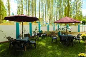 a group of tables and chairs with umbrellas at HOTEL NATURE's LAND in Leh